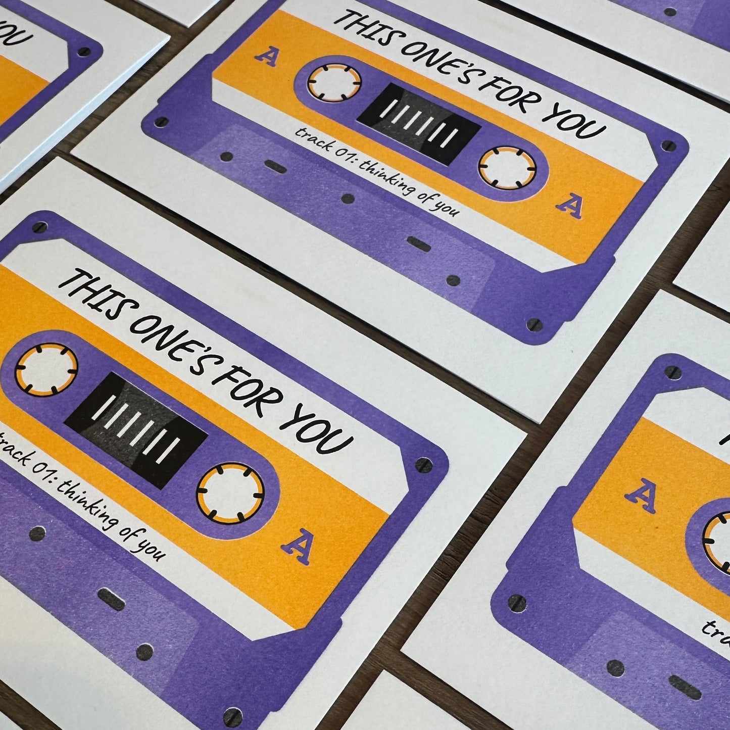 Pattern of cassette tapes with 'This one's for you' text on a white background