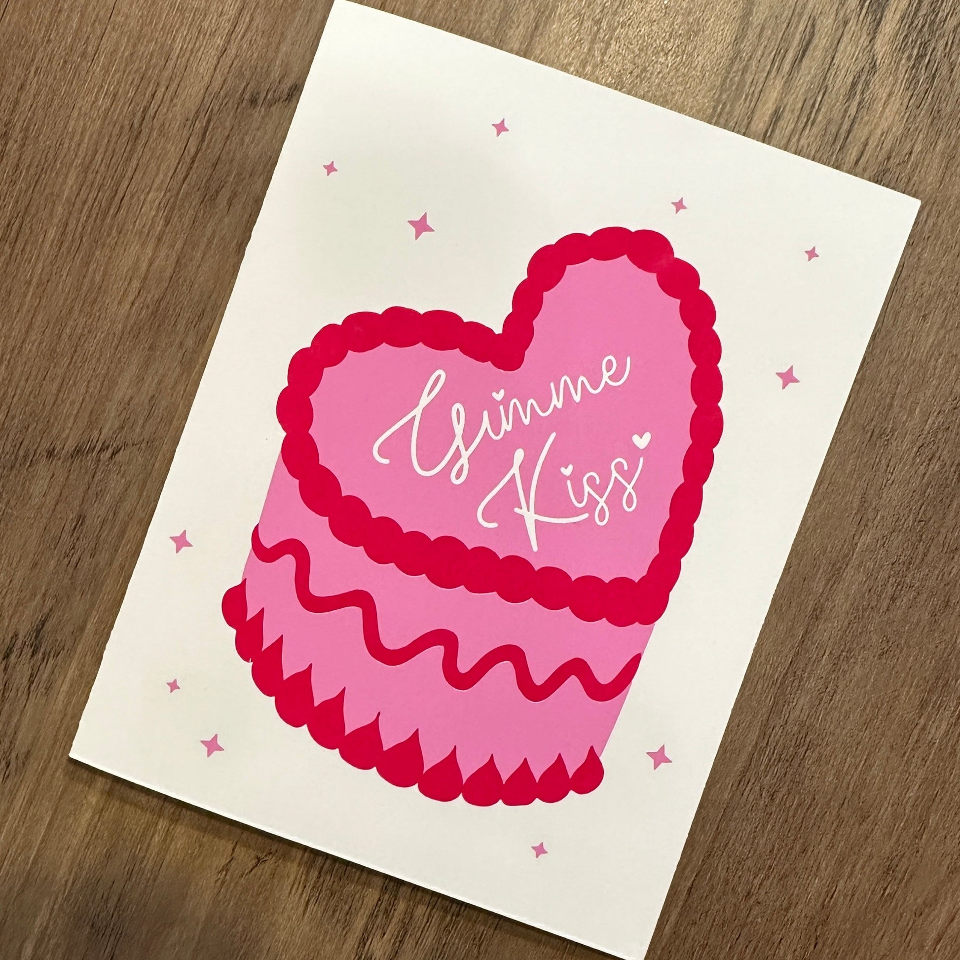 Card with a pink heart and 'Hugs & Kisses' text on a wooden surface