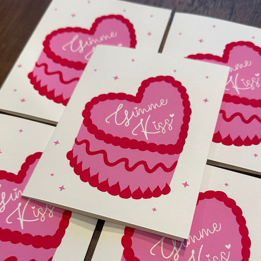 Set of Valentine's Day cards with pink hearts and cake design on a wooden surface.