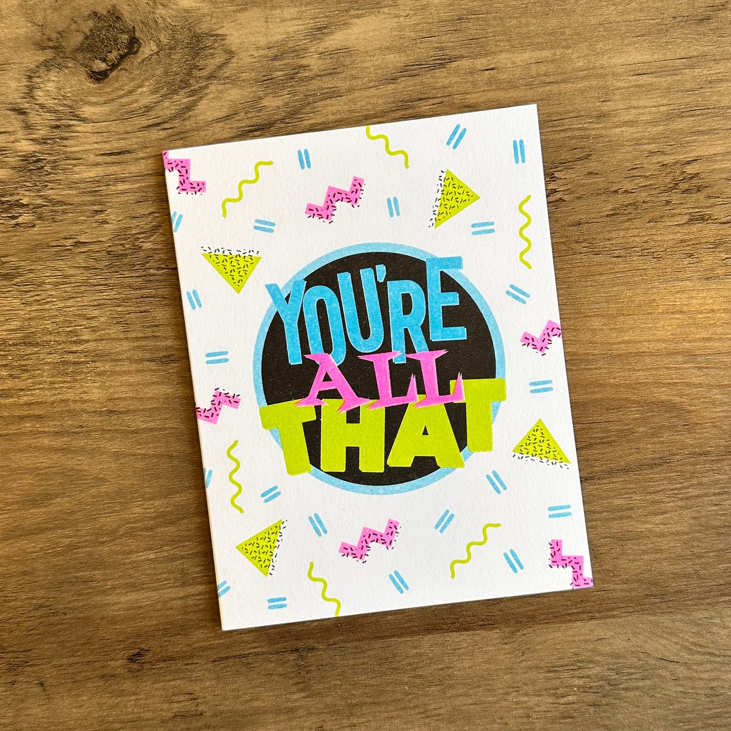 Colorful card with 'You're All That' text on a wooden surface