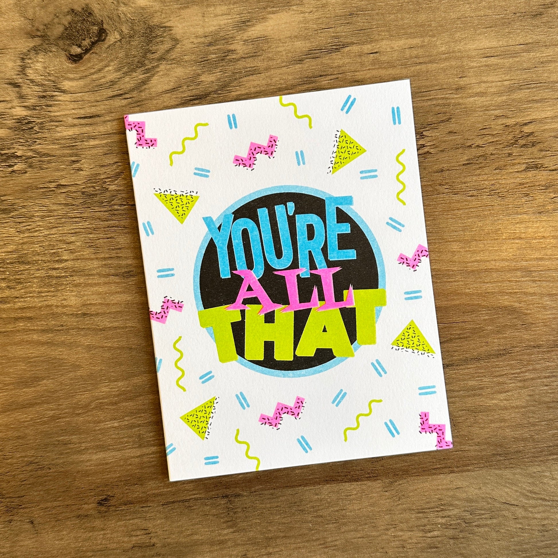 Colorful card with 'You're All That' text on a wooden surface